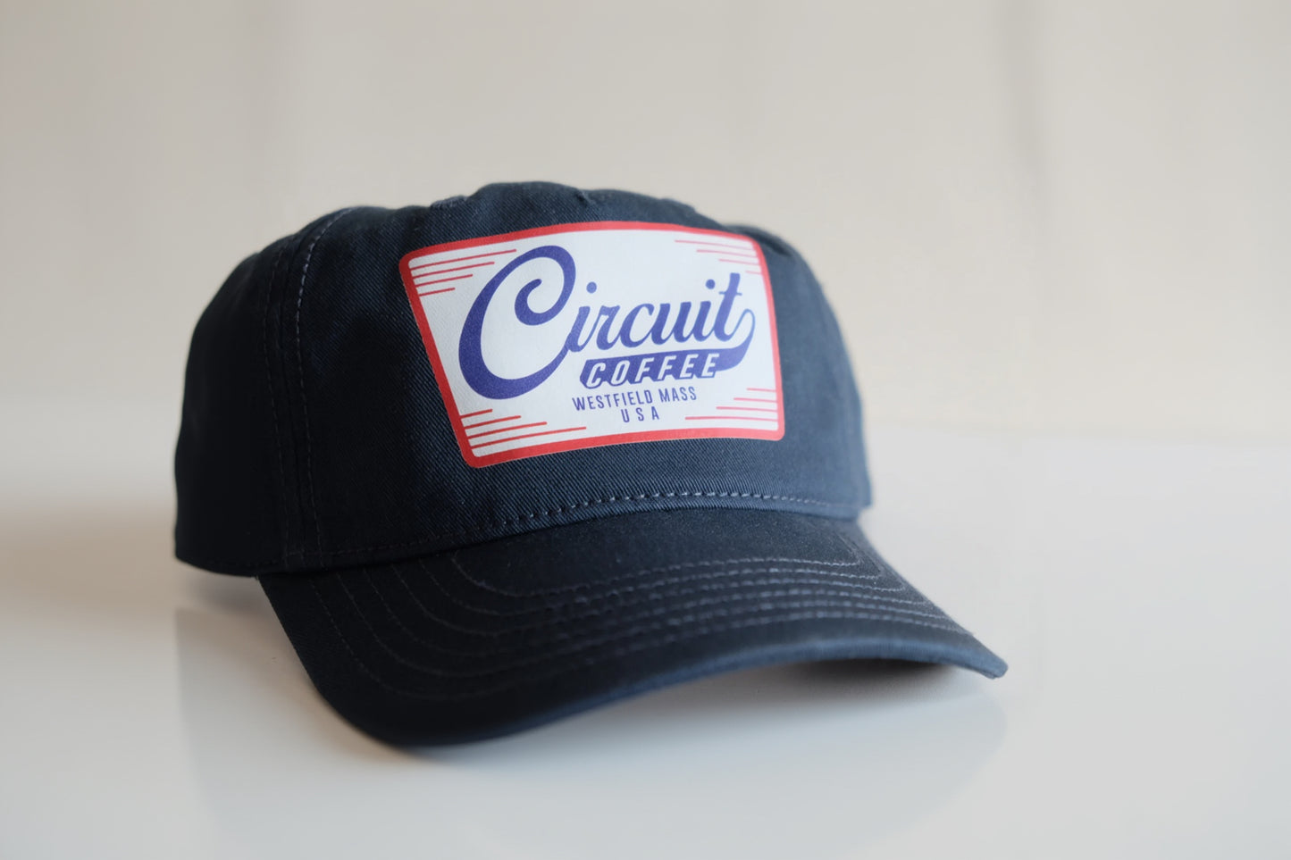 Navy blue cap with 'Circuit Coffee' logo on a light gray background